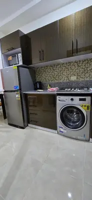 a kitchen with a refrigerator and a washing machine at Tiba Golden Golden Coast Hurghada in Hurghada