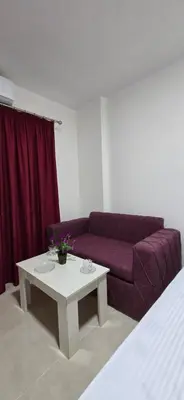 a living room with a purple couch and a table at Tiba Golden Sea Harmony Hurghada in Hurghada
