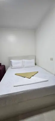 a white bed with a gold napkin on it at Tiba Golden Sea Harmony Hurghada in Hurghada