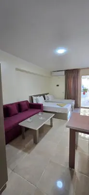 a living room with a purple couch and tables at Tiba Golden Blue Mirage Hurghada in Hurghada