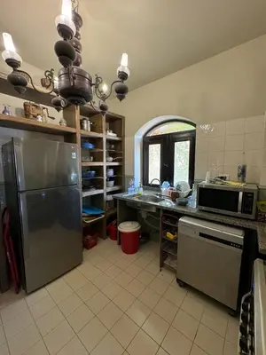 a kitchen with a stainless steel refrigerator and a microwave at El Gouna 4 Bedroom 4 Bathroom Lagoon villa in Banī Ghālib