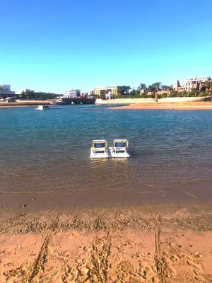 two boats floating in the water near a beach at El Gouna 4 Bedroom 4 Bathroom Lagoon villa in Banī Ghālib