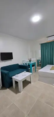 a living room with a blue couch and a table at Tiba Golden Palm Hurghada in Hurghada