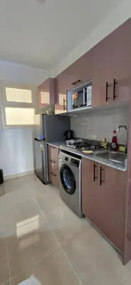 a kitchen with a stove and a washing machine at Tiba Golden Crystal Lagoon Hurghada in Hurghada