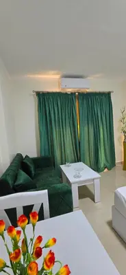 a living room with a green couch and a table at Tiba Golden Sapphire Hurghada in Hurghada