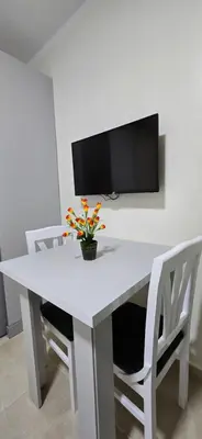 a white table with white chairs and a tv on a wall at Tiba Golden Sapphire Hurghada in Hurghada