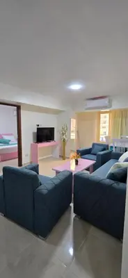 a living room with blue couches and a tv at Tiba Golden Sunset Oasis Hurghada in Hurghada