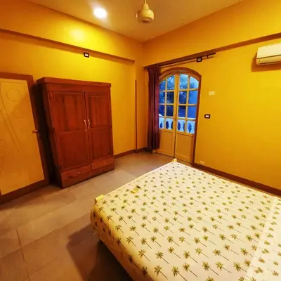 a bedroom with a bed and a wooden cabinet at Villa Karmen in Luxor