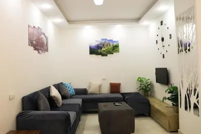 a living room with a blue couch and a tv at Golden Home Hurghada El Kauser in Hurghada