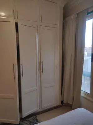 a bedroom with white cabinets and a window at Summer land in Hurghada