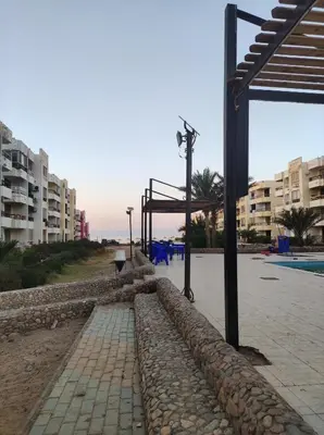 a walkway next to a pool with some buildings at Summer land in Hurghada