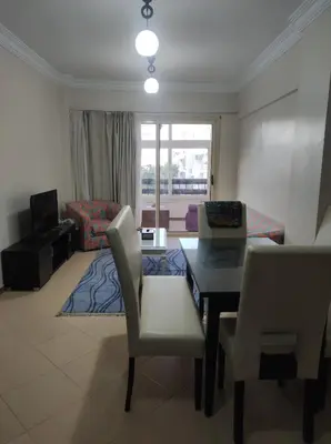 a living room with a table and chairs and a couch at Summer land in Hurghada