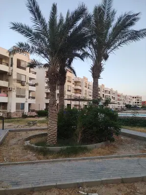 two palm trees in front of a building at Summer land in Hurghada