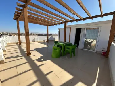 a patio with green chairs and tables on a building at Sea view chalet in Sahl Hasheesh