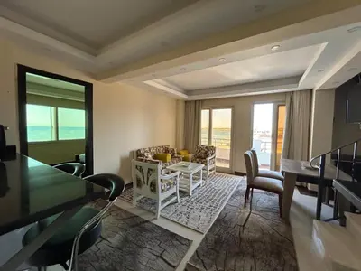 a living room with a table and chairs and a dining room at Sea view chalet in Sahl Hasheesh