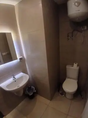 a bathroom with a white toilet and a sink at Cozy Studio in Hurghada