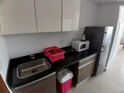 a kitchen with a sink and a microwave and a refrigerator at Cozy Studio in Hurghada