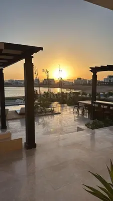 a sunset over a patio with a table and benches at Gouna's Best Villa in Hurghada