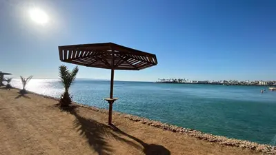 a umbrella sitting on a beach next to the water at TiBa Golden Resort in Hurghada