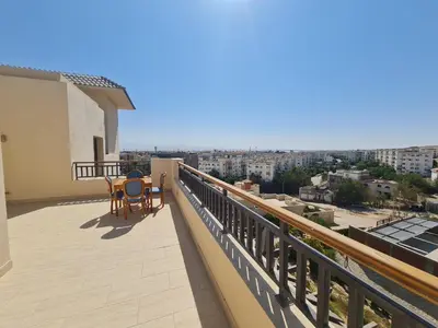 a balcony of a house with a table and chairs at AlDau Heights Modern Studio with Terrace, Mountain & City View in Hurghada