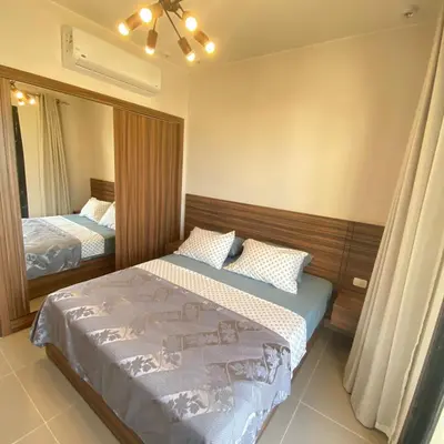 a bedroom with two beds and a mirror at Jade 18 A in Hurghada