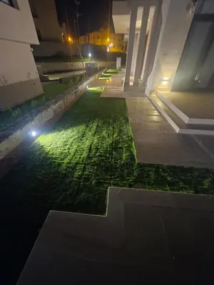a courtyard at night with lights on the grass at Jade 18 A in Hurghada
