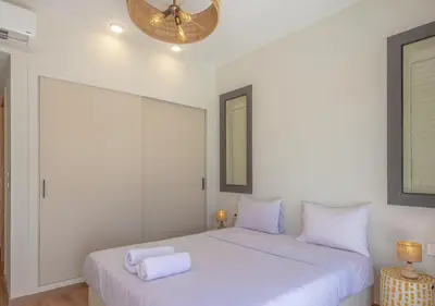 a white bedroom with two beds and a ceiling fan at Calm 3BR House in Shedwan Gouna BBQ, Pool & Lagoon in Hurghada