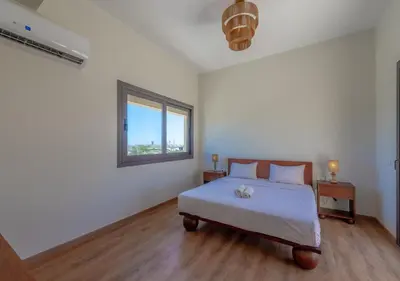 a white bedroom with a bed and a window at Calm 3BR House in Shedwan Gouna BBQ, Pool & Lagoon in Hurghada