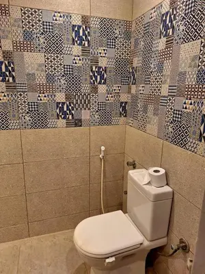 a bathroom with a toilet and tiles on the wall at Orientalna Willa in Hurghada