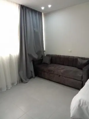 a living room with a couch in front of a window at Scandic Resort Hurghada in Hurghada