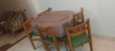 a table with four chairs and a table with a cloth on it at شقه للايجار in Luxor