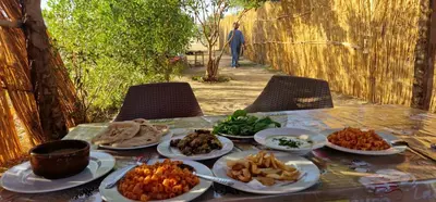 a table with plates of food on top of it at Gateway to the Stars restaurant & camping in Al Aqālitah