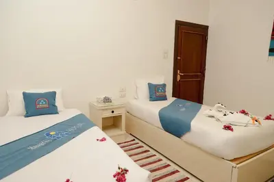 two beds in a room with blue and white at Ekadolli Nubian house- by kerma hospitality in Aswan