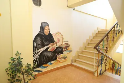 a painting of a woman sitting on the stairs at Ekadolli Nubian house- by kerma hospitality in Aswan
