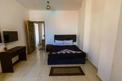 a bedroom with a bed and a television in it at Fox House Resort in Hurghada