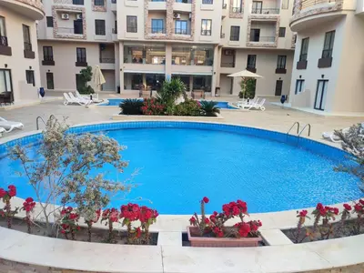 a swimming pool in front of a building at Pohodové bydlení v Hurghade in Hurghada