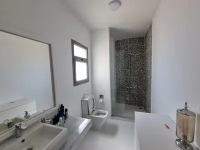 a white bathroom with a sink and a toilet at Spacious Penthouse in Hurghada