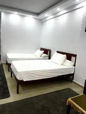 two beds in a room with white walls at Palma Resort in Hurghada