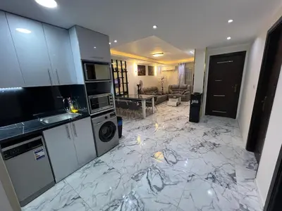 a kitchen with a marble floor and a living room at Hub resort Aqua park in Hurghada