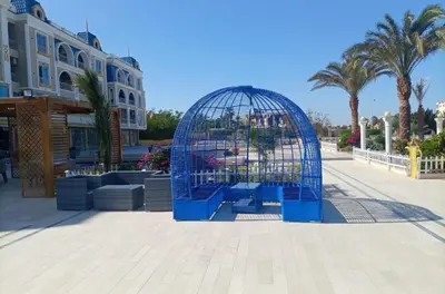 a blue bird cage sitting in a plaza at Hub resort Aqua park in Hurghada