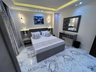 a bedroom with a large bed with a marble floor at Hub resort Aqua park in Hurghada