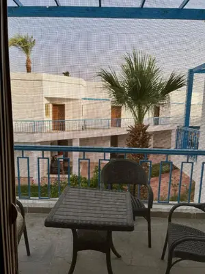 a table and chairs on a balcony with a view of a building at Dream Chalet In Mirage Bay Resort in Hurghada
