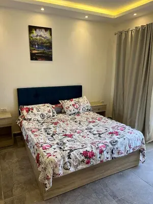 a bedroom with a bed with a floral comforter at Dream Chalet In Mirage Bay Resort in Hurghada