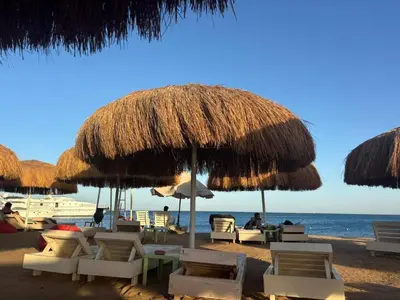 a beach with chairs and umbrellas and the ocean at marvel princes in Hurghada