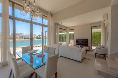 a living room with a glass table and a couch at The Lake View Villa 4BR at Tawila El Gouna in Hurghada