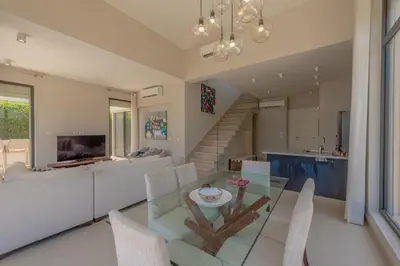 a dining room and living room with a glass table and chairs at The Lake View Villa 4BR at Tawila El Gouna in Hurghada