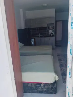 a small bedroom with two beds and a kitchen at Tiba view in Hurghada