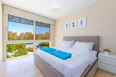 a bedroom with a large bed and a window at Special apartment with Pool and Seasideview, El Gouna in Hurghada