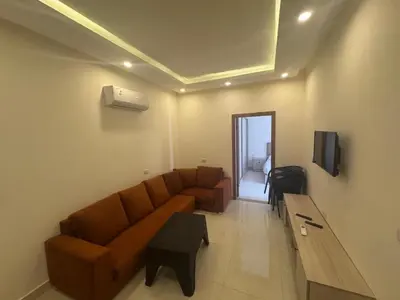 a living room with a brown couch and a tv at شاليه بقرية ميراج باي in Hurghada