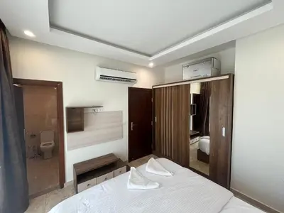 a bedroom with a white bed and a bathroom at شاليه بقرية ميراج باي in Hurghada